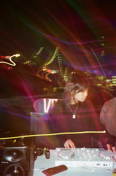 Linda Xue Djing in front of the Brooklyn Skyline, heavy light leaks and light trails shot on film.