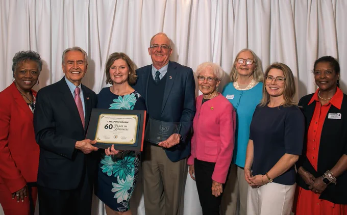 Reza Jafari accepts the 60 Years of Serving certificate from a Talbot Chamber of Commerce representative, in a group of Board of Trustees members