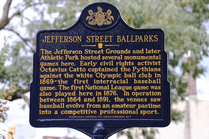 Historical marker placed at the site of Philadelphia’s Jefferson Street Grounds and Athletic Park, seen in 2017. (Courtesy of Matt Albertson)

The marker reads:

JEFFERSON STREET BALLPARKS

The Jefferson Street Grounds and later Athletic Park hosted several monumental games here. Early civil rights activist Octavius Catto captained the Pythians against the white Olympic ball club in
1869—the first interracial baseball game. The first National League game was also played here in 1876. In operation between 1864 and 1891, the venues saw baseball evolve from an amateur pastime into a competitive professional sport.