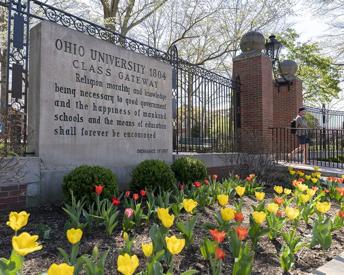 Ohio University Class Gateway sign with yellow and orange flowers in front of it