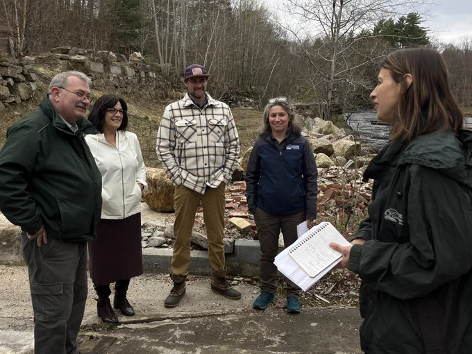 One person speaking to a group of four others about the site.
