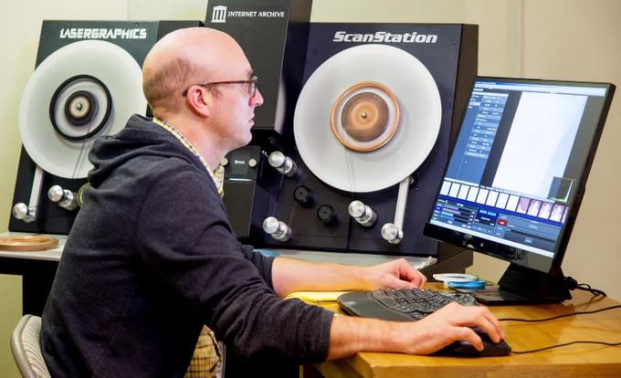A person at the Internet Archive operating a Lasergraphics ScanStation digital film scanner, in the procress of scanning 8mm film.