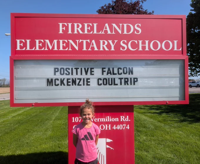 Student in front of the sign