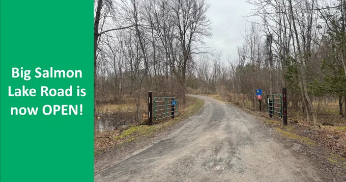A two part image:
On the left, there is a green block that reads "Big Salmon Lake Road is now OPEN".
On the right, there is a picture of the Big Salmon Lake road with the green gate open to allow traffic through for the season.