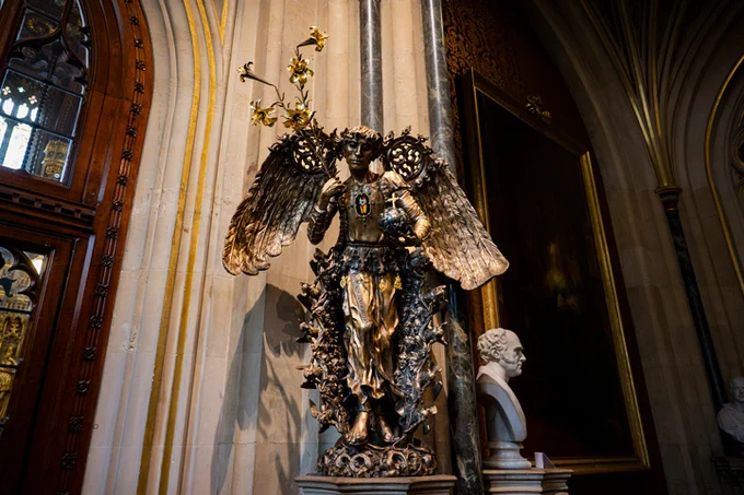 A new bronze angel by Eleanor Crook situated on a high plinth in the Norman Porch of the Houses of Parliament, holding a celestial orb and a sheaf of gilded lilies