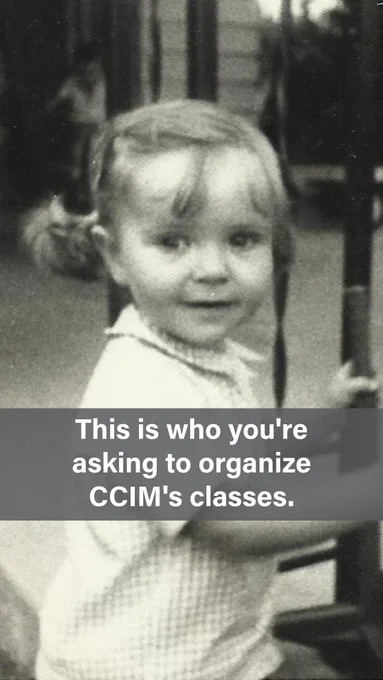 A black-and-white vintage photo of a smiling toddler girl with light hair in small pigtails, wearing a light-colored top, standing near what appears to be a metal railing or fence outdoors. Text overlay reads: "This is who you're asking to organize CCIM's classes."