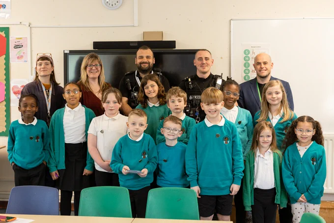 Garden City Academy pupils smiling for a photo with local councillor, police officers, teachers and Settle colleagues.