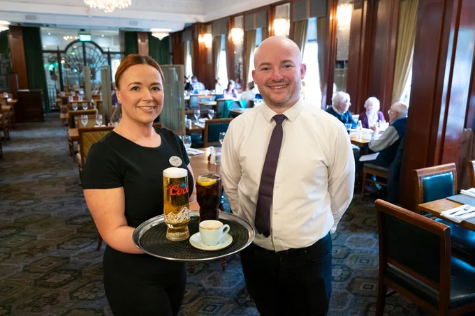 2 staff at The Royal Toby Hotel serving drinks in the dining room. 