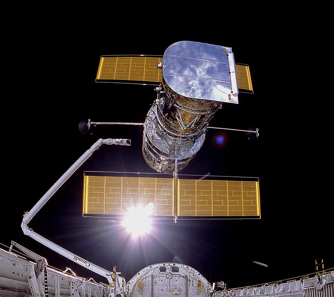 In this photograph, the Hubble Space Telescope (HST) was being deployed on April 25, 1990. The photograph was taken by the IMAX Cargo Bay Camera (ICBC) mounted in a container on the port side of the Space Shuttle orbiter Discovery (STS-31 mission). The purpose of the HST, the most complex and sensitive optical telescope made up to that date, was to study the cosmos from a low-Earth orbit for 15 years or more. Now 36 years later, it continues to reveal new details about the universe.