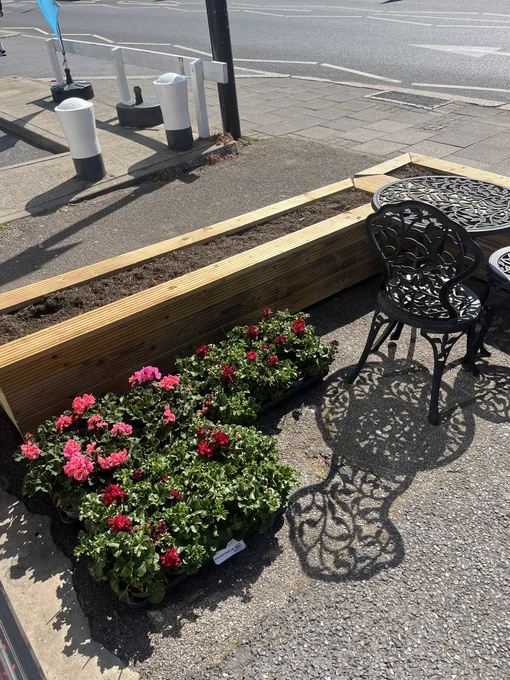 New pink and red plants to go in wooden planters with outside seating at Love & Dye salon