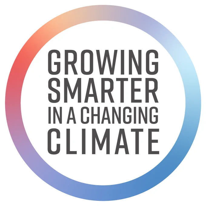 A circular logo with a gradient border from red to blue. Inside, the text reads "Growing Smarter in a Changing Climate.