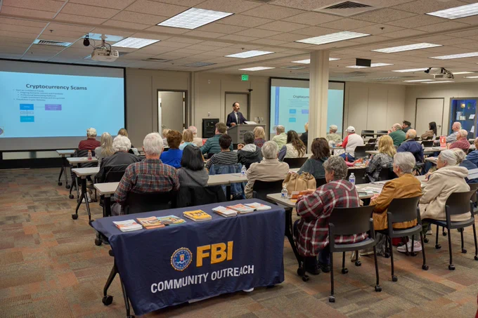 Acting Assistant Special Agent in Charge Mike Montoya presents on fraud to a room of people during a joint AARP town hall.