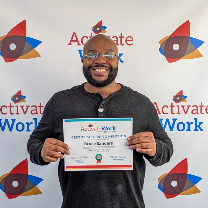 Person holding a certificate of completion from ActivateWork with their name visible, standing in front of a branded backdrop.