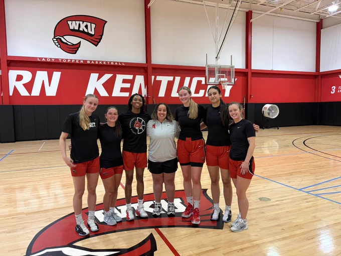 Group photo of Lady Topper players and GA Kennedy Rowan