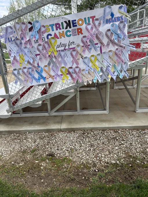 Sign with cancer ribbons representing the people the softball team is fighting for.