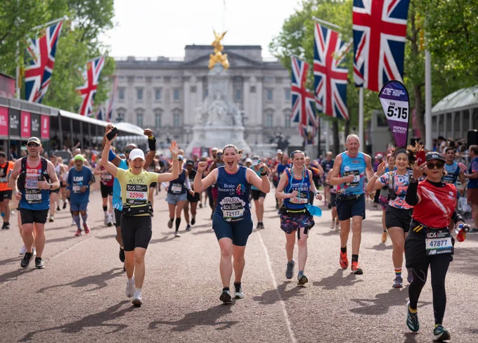 london marathon runners smiling as they run down the home stretch on the mall