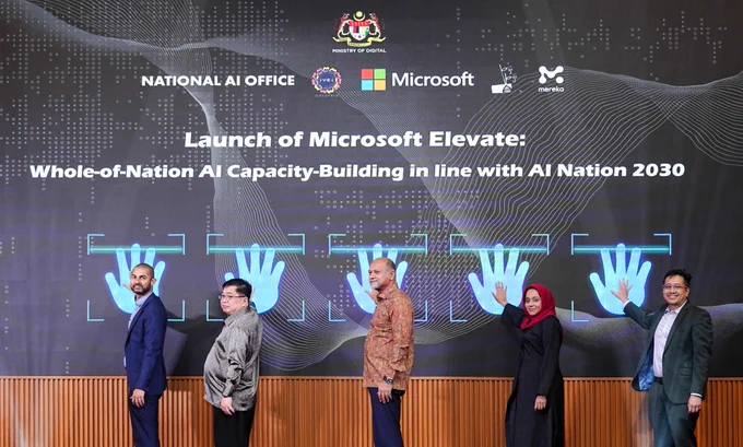 Officials launching Microsoft Elevate event with digital handprint display on screen.