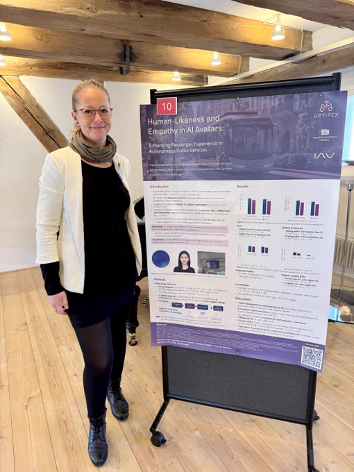 Image shows a person standing beside a poster.