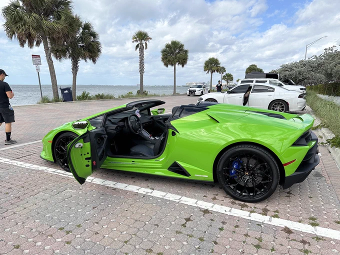 a bright green Lamborghini Huracán parked near a beach in Miami