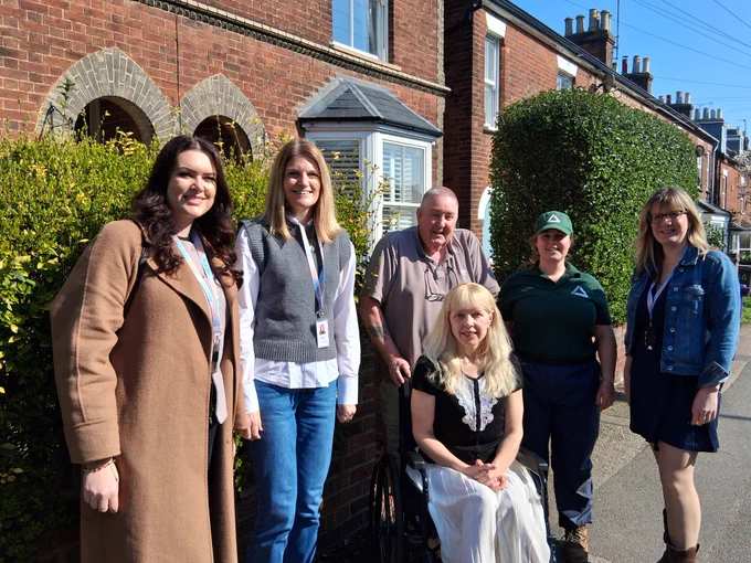 Two Settle colleagues with two residents, one a wheelchair user, and two team members from Groundwork East, outside the home.