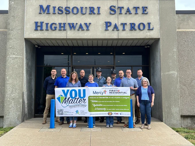 Troop D members holding sign in front of Troop D Hq.  The sign represents child abuse recognition month and our partnership with @theCACozarks.