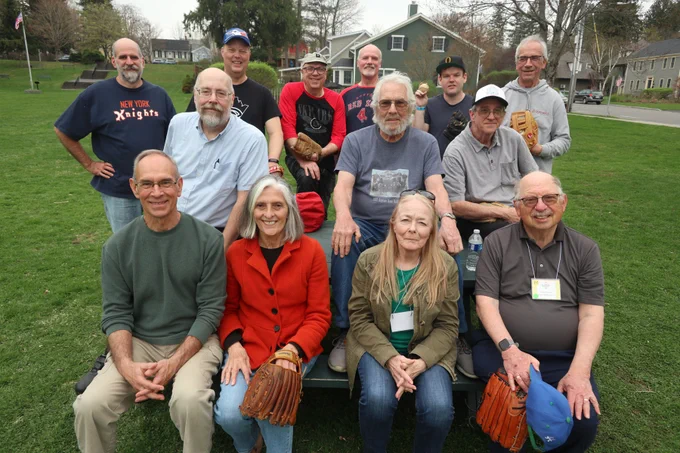A group of people pause their game of playing catch to take a photo on the grass across the street from the Baseball Hall of Fame in Cooperstown, New York. From the 2025 SABR Ivor-Campbell 19th Century Base Ball Conference.