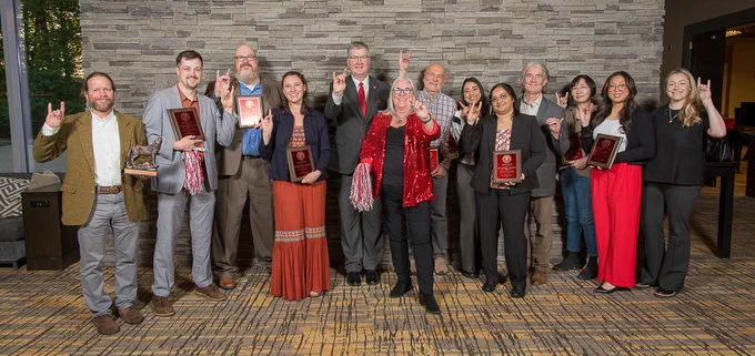 Group of CALS Awards for Excellence honorees standing with CALS Dean Garey Fox holding awards and smiling for a celebratory photo.