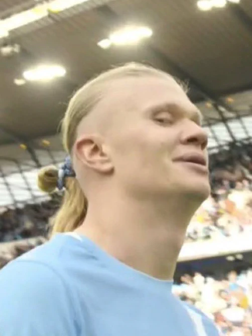 A screenshot of Erling Haaland giving a side-eye to the camera following the full time whistle with a smirk.