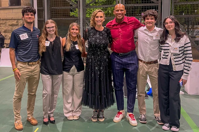 Six people pose for a photo with former Pittsburgh Steeler Ryan Shazier at Acrisure Stadium.