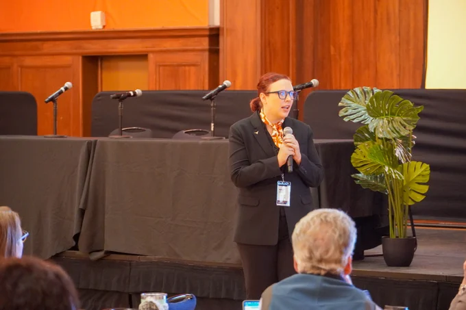 Kasey Ford speaks during a workshop at Responsible AI for Education while attendees participate from round tables.