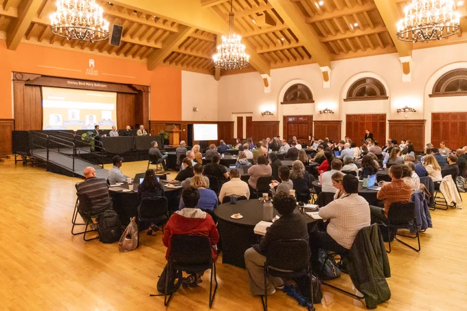 Attendees seated at round tables in the Shirley Bird Perry Ballroom during a panel at Responsible AI for Education.