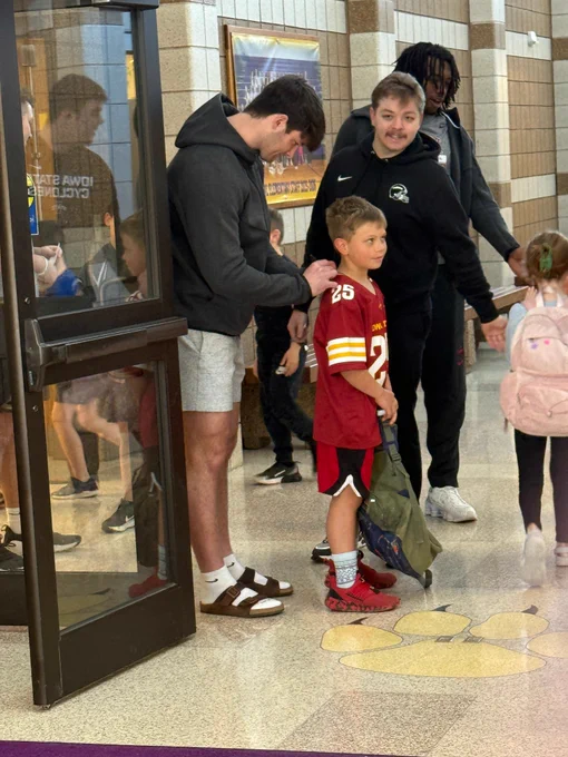 ISU football player signing a student's ISU football jersey