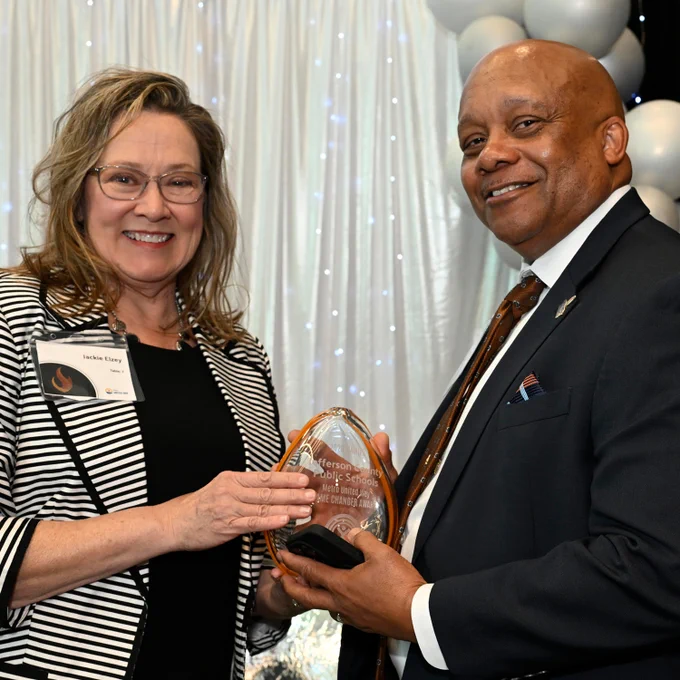 Dr. Yearwood accepts an award from another adult.