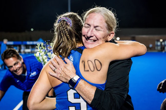 Pam Bustin smiling and hugging senior player