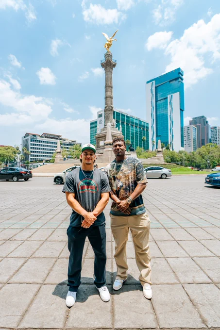 Alek Thomas and Geraldo Perdomo pose for a photo in front of The Angel of Independence in Mexico City. 