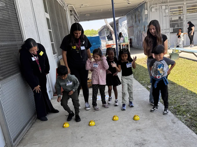 Students at 186th Street Elementary School engaging in robotics activities and guided by Liberal Studies students