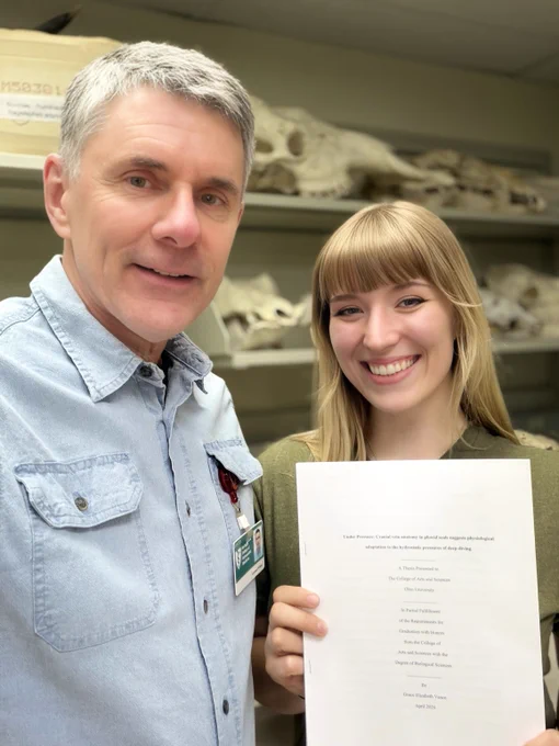 Graduating Ohio University senior Grace Vance holds her complete and submitted senior honors thesis on cranial vascular adaptations for deep diving in seals. Standing next to her is Witmer, Grace's proud research mentor.