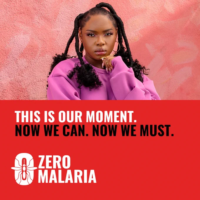Yemi Alade looks confidently down the camera. She wears a pink sweater top. In red and black bold text, it reads: This is our moment. Now We Can. Now We Must. Zero Malaria.
