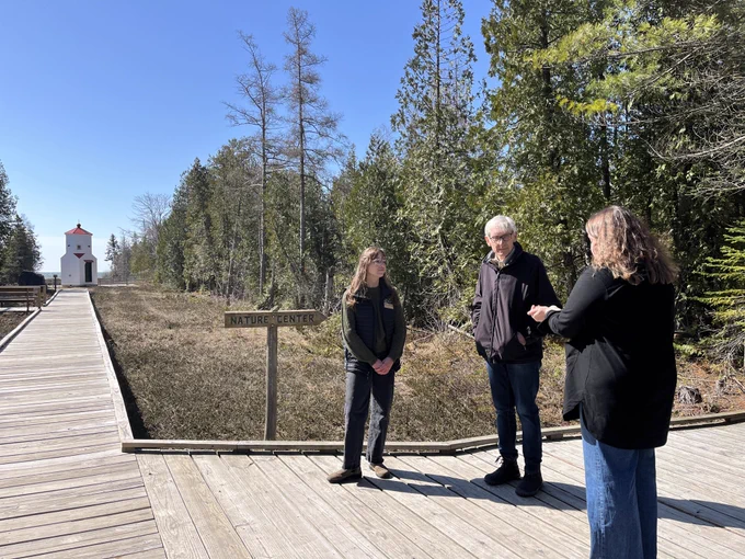 Gov. Evers stands on boardwalk with staff from The Ridges