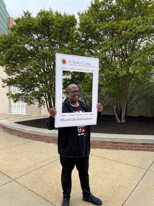 Dean Graham holds a frame around his face that says #LookLikeAnEngineer