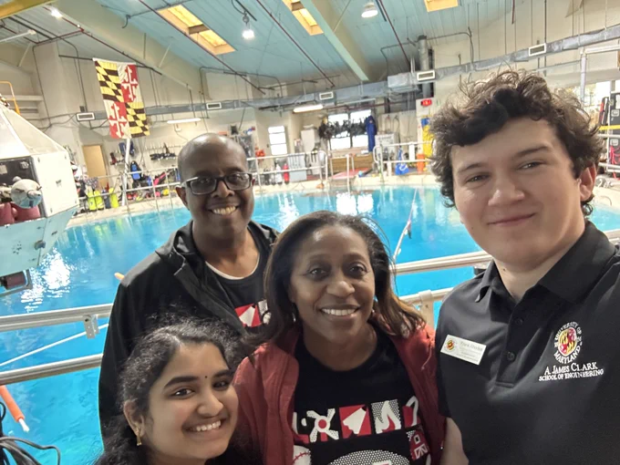 Dean Graham poses with others before a water tank