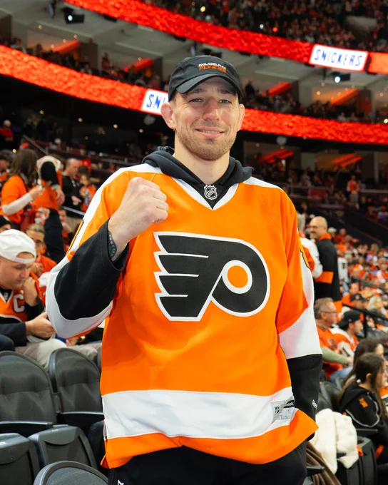 Kyle Daukaus smiling for a photo wearing a Flyers jersey