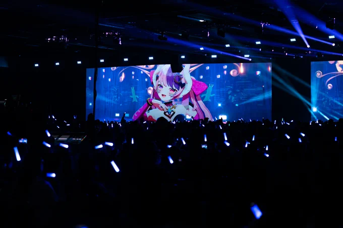 A photograph of Ironmouse performing at Fan Festival 2026 in Anaheim, with the crowd waving blue light sticks.