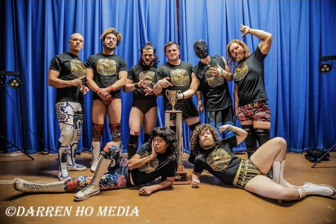 365 King of the Island participants posing with trophy. Back row: Travis Williams, Damian Desire, Judas Icarus, Elliot Tyler, Inferno, Marz The Specialist. Front row: Richie Coy, Josh Cadwell. Photo by Darren Ho Media