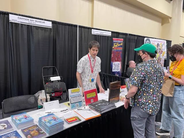 Cartoon Art Museum curator Andrew Farago talks with an attendee at Comic Con Oakland