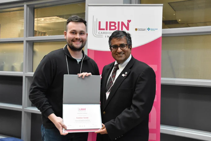 Connor Snow receiving his award from Dr. Satish Raj at the 2026 Tine Haworth Cardiovascular Research Day.