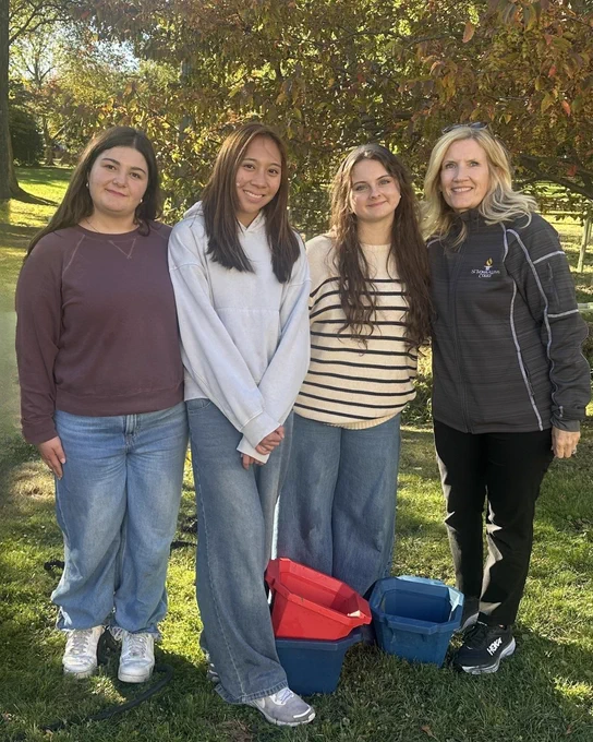 Laurie with 3 students outside at Trees for Tribs event planting trees