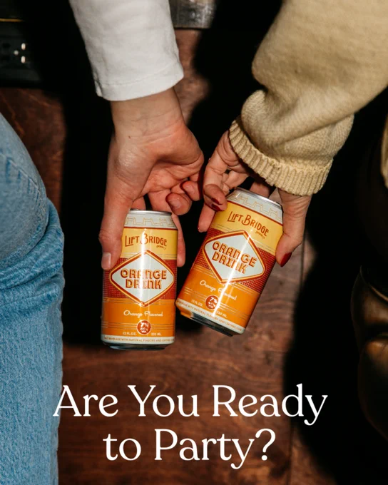Two people clink cans of Lift Bridge Orange Drink, creating a festive and inviting atmosphere. The text 'Are You Ready to Party?' adds to the celebratory mood.