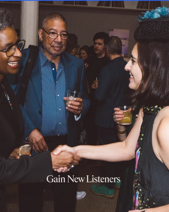 People engage in conversation and handshakes at a social event, fostering connections. The mood is lively and professional.