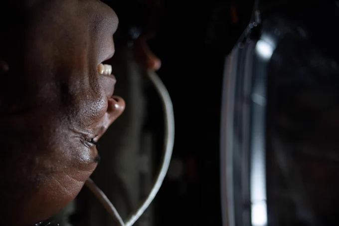 A close-up portrait of Victor Glover\u2019s smiling face as he looks out the window of the Orion spacecraft. Credit: NASA